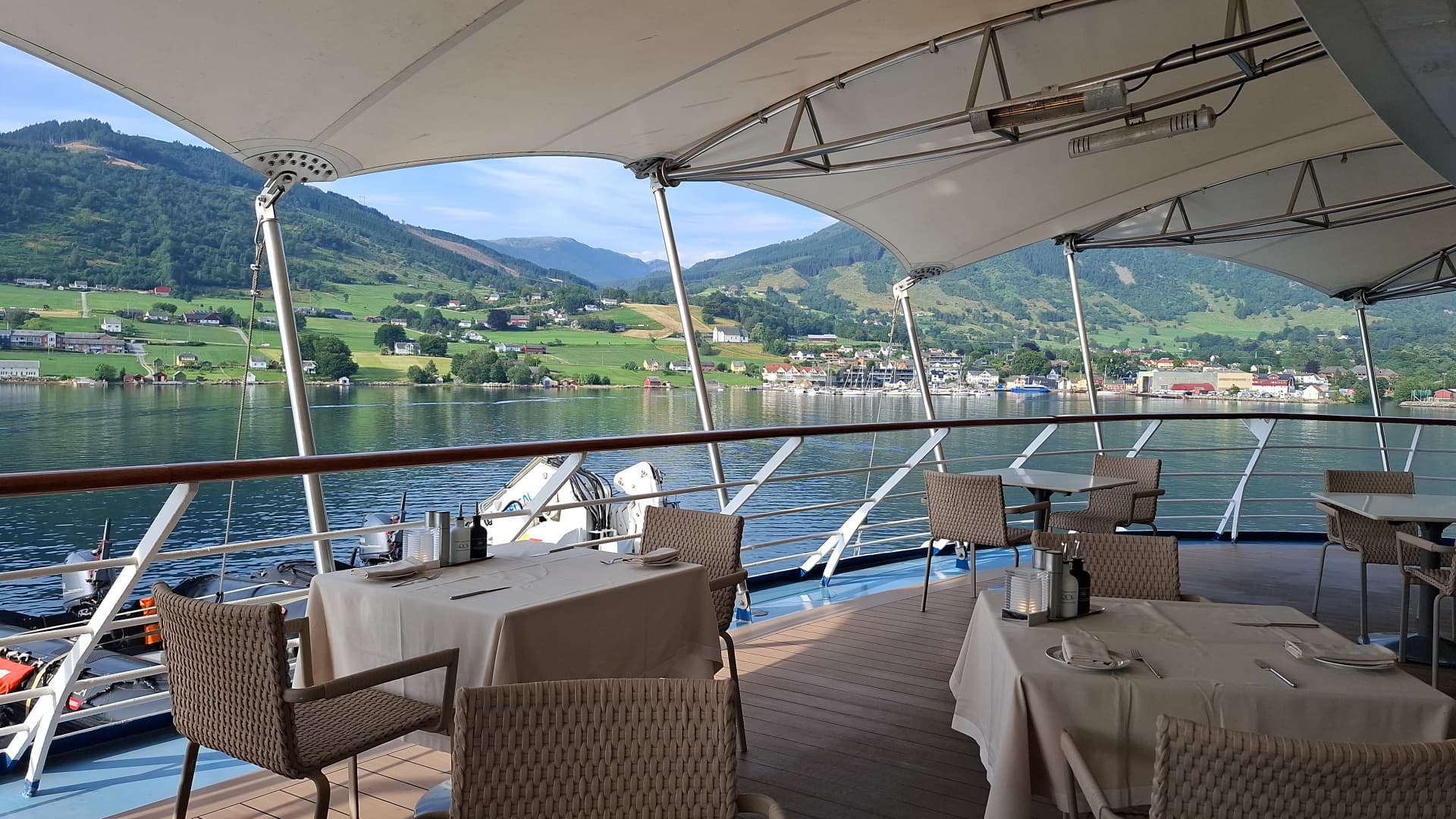 Buitendek met gedekte tafels aan boord in een Noorse fjord