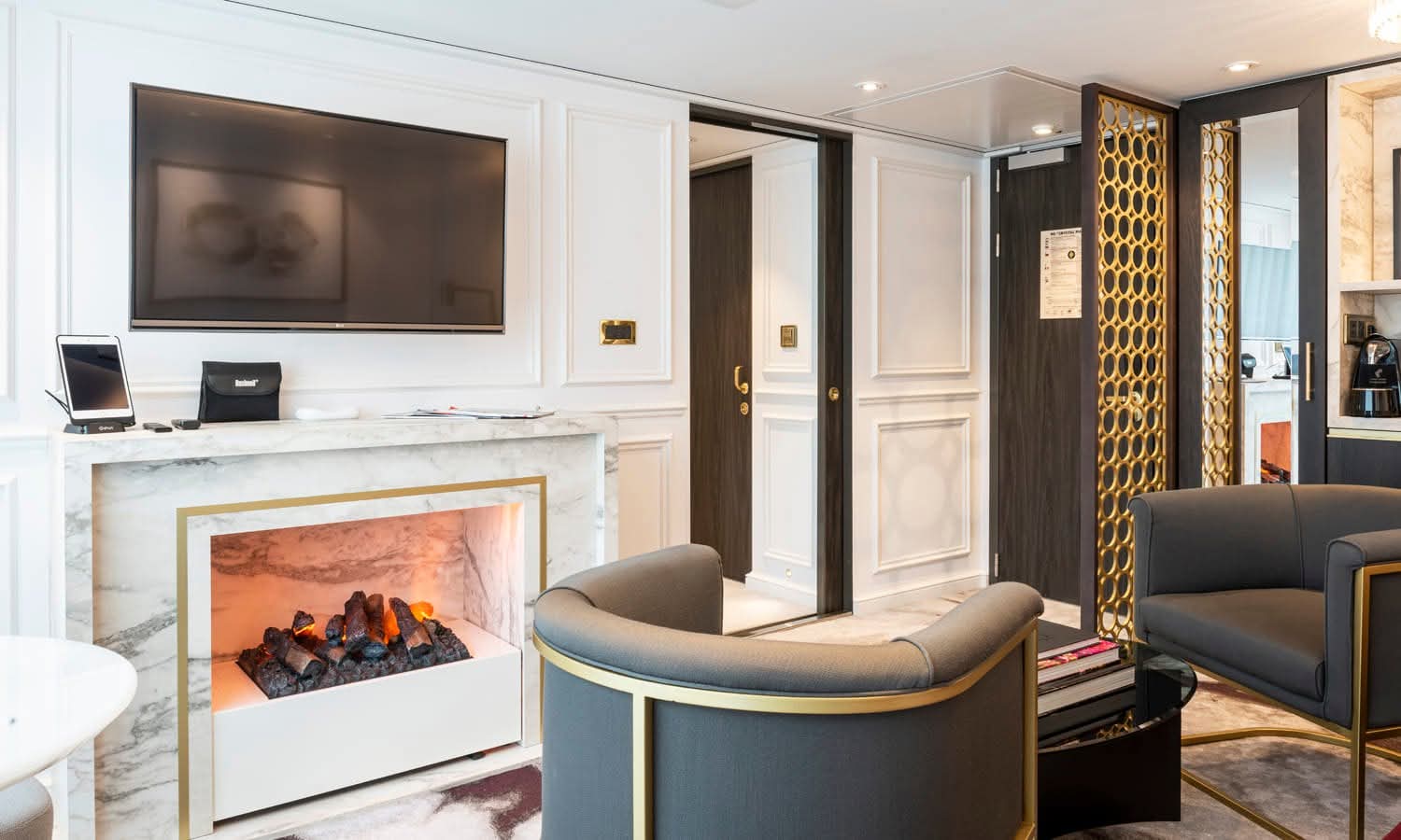 Salon van een Riverside-suite met marmeren haard
