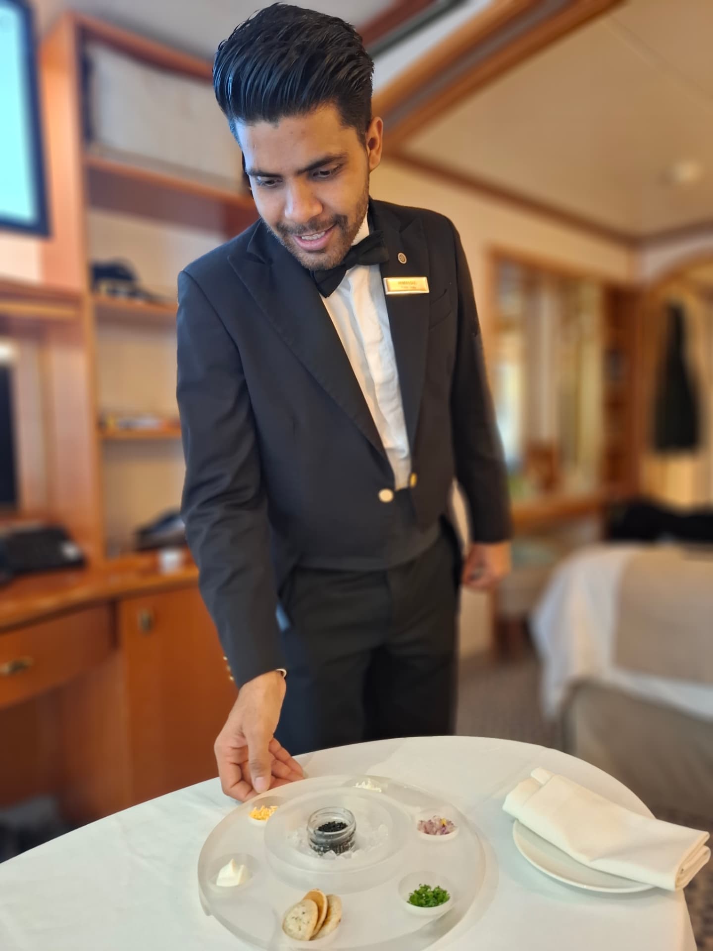 Butler serveert kaviaar in een suite aan boord